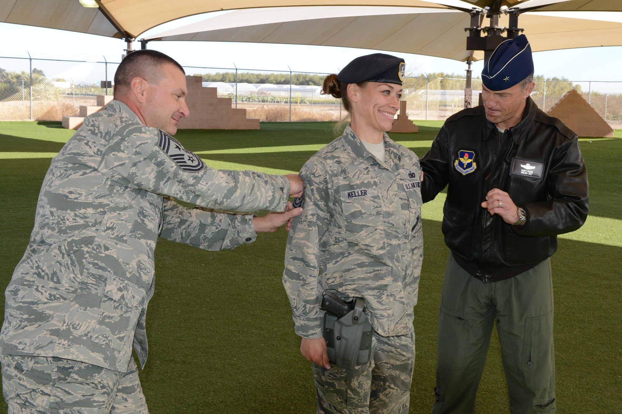 Staff Sgt. Jessica Keller, 56th Security Forces Squadron military working dog handler, gets step promoted by Gen. Scott Pleus, 56th Fighter Wing commander, and Chief Master Sgt. John Mazza, 56th FW command chief, at Luke Air Force Base, Arizona, Dec. 28, 2015. 
