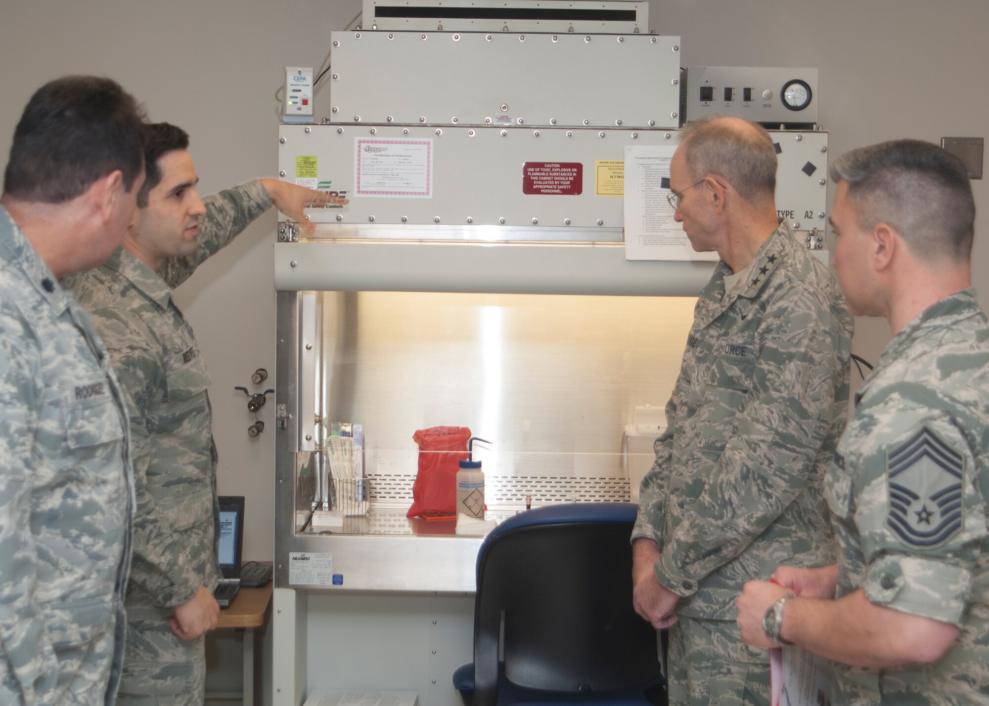 Lt. Col. Ethiel Rodriquez, Diagnostics and Therapeutics Squadron Laboratory Flight Commander and laboratory technician SSgt. John Reeves brief the Air Force Surgeon General, Lt. Gen. Mark Ediger and the Chief, Medical Enlisted Force, CMSgt. Jason Pace during their visit to the Wright-Patterson Medical Center on Jan. 13, 2015. 
