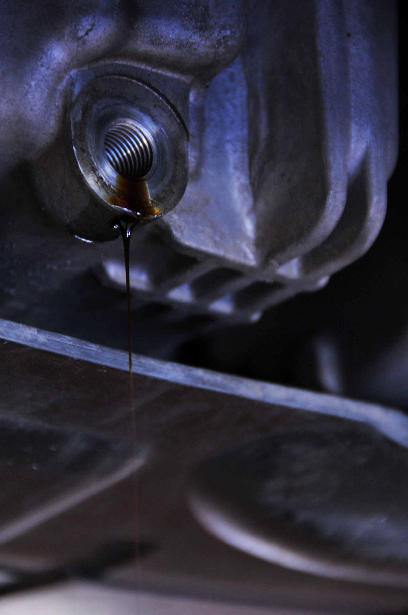 Oil seeps from a drain plug during an oil change at the 2nd Force Support Squadron Auto Hobby Center, Barksdale Air Force Base, La., Jan. 13, 2016. Customers may be eligible for a free oil change if their spouse is deployed. For more information, contact the Airman and Family Readiness Center at 456-8400. (U.S. Air Force photo by Senior Airman Amanda Morris)