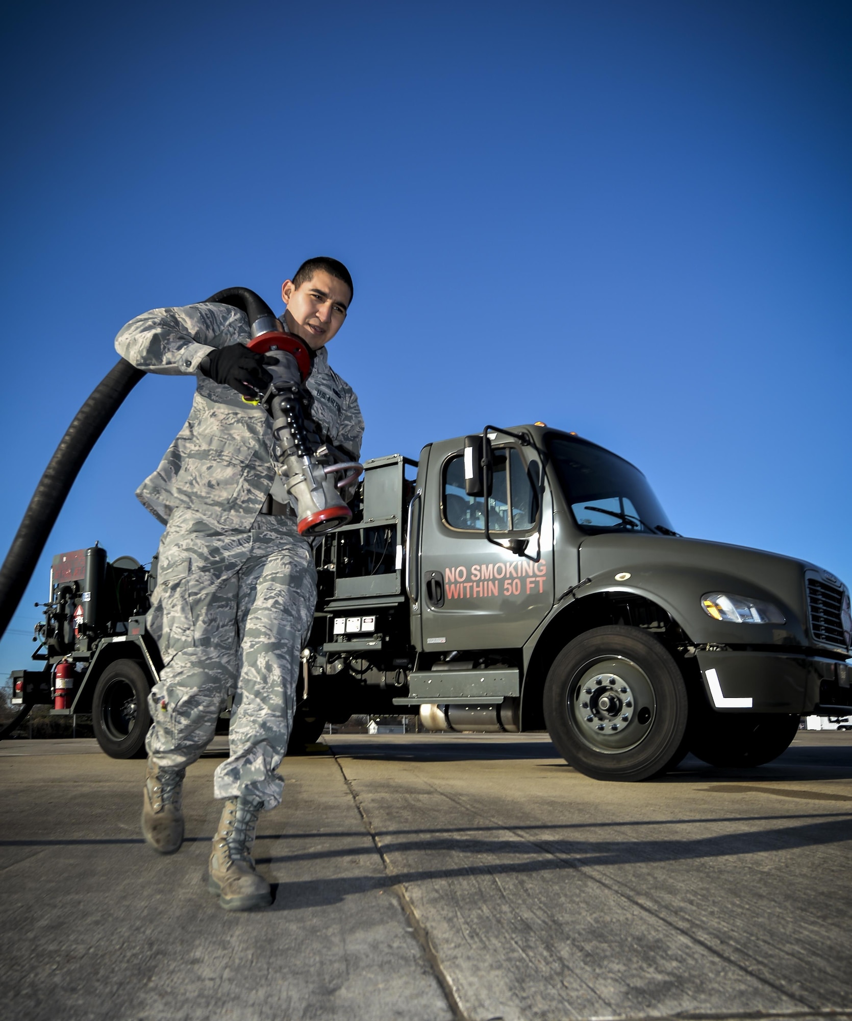 Airman 1st Class Ivan Saldivar, 2nd Logistics Readiness Squadron fuel distribution operator, carries a fuel hose from an R-12 hydrant servicing truck at Barksdale Air Force Base, La., Jan. 11, 2016. This truck fuels aircraft faster than conventional trucks by pumping fuel directly from the underground piping system. (U.S. Air Force photo/Airman 1st Class Mozer O. Da Cunha)