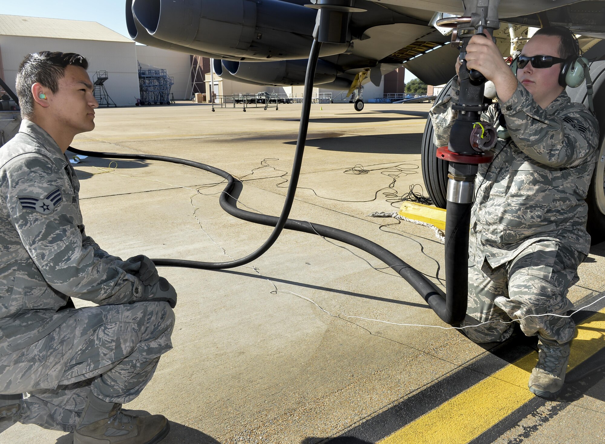 Senior Airman William Burford, 2nd Logistics Readiness Squadron fuel distribution operator, monitors Senior Airman Michael Breiter, 2nd Maintenance Squadron crew chief, as he attaches a fuel nozzle to a B-52 Stratofortress at Barksdale Air Force Base, La., Jan. 12, 2016. The B-52 can hold about 100,000 to 200,000 pounds of fuel per sortie, taking one to two hours to fill the tanks. (U.S. Air Force photo/Airman 1st Class Mozer O. Da Cunha)