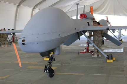 Unmanned aerial system repairers from Company F, 227th Aviation Regiment, 40th Combat Aviation Brigade, inspect an MQ-1C Gray Eagle in the Middle East, Jan. 7, 2016. Company F Gray Eagles provide armed aerial reconnaissance for stability operations in the Middle East. 