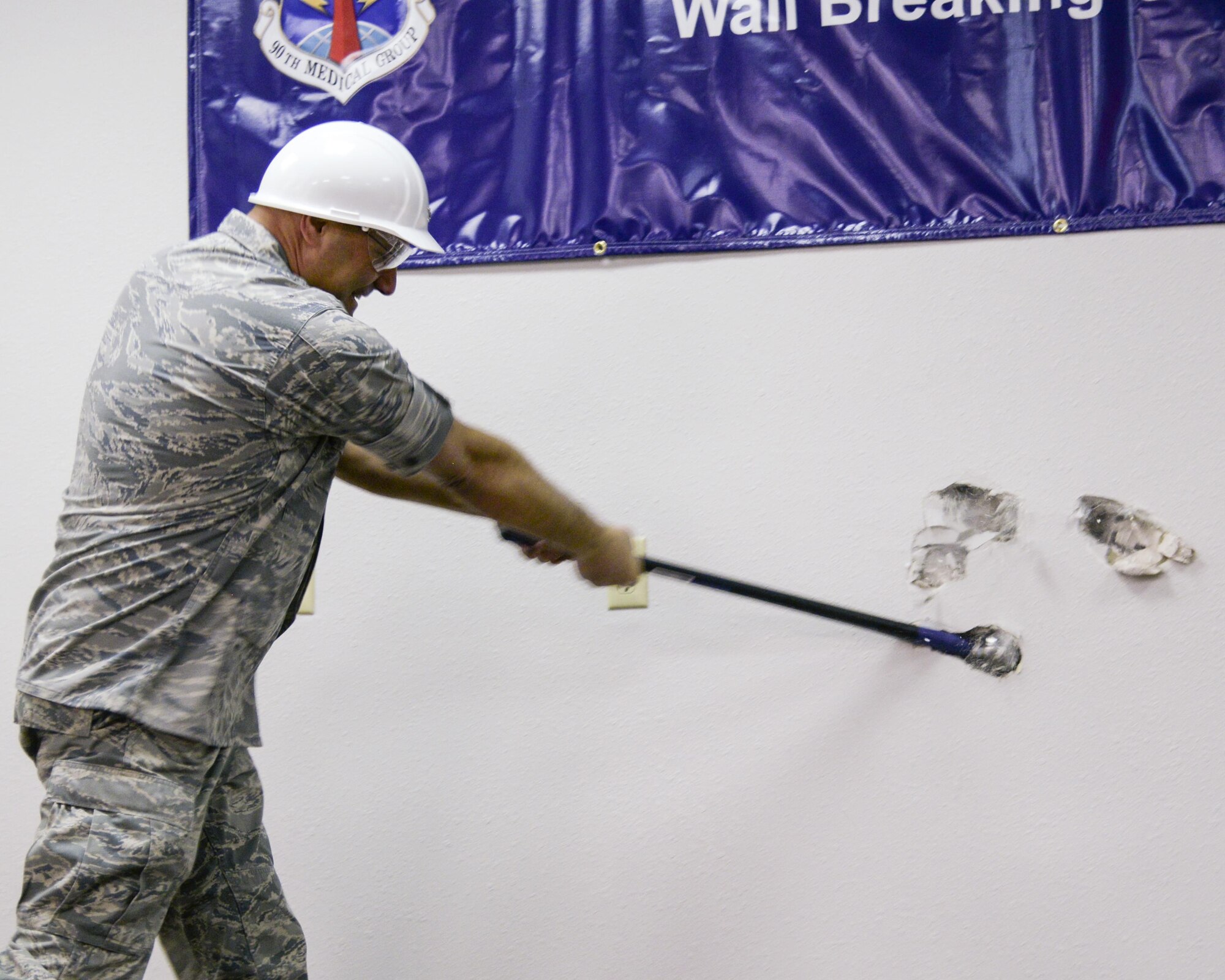 Col. Stephen Kravitsky, 90th Missile Wing commander, takes a sledgehammer to a wall in the 90th Medical Group Medical Treatment Facility during a ceremony Jan. 19, 2015, on F.E. Warren Air Force Base, Wyo. Construction to expand the MTF is scheduled to begin in February, creating a more patient-friendly and efficient atmosphere. (U.S. Air Force photo by Airman 1st Class Malcolm Mayfield)