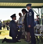 Lieutenant Col. Andrew Campbell, 36th Airlift Squadron commander, presents a folded American flag to Eva Hake during Senior Airman Jeremy M. Jutba-Hake's funeral, Tuesday, Jan. 20, 2016, at Mililani Memorial Park, located in Mililani, Hawaii. (U.S. Air Force photo by Staff Sgt. Christopher Stoltz/Released)