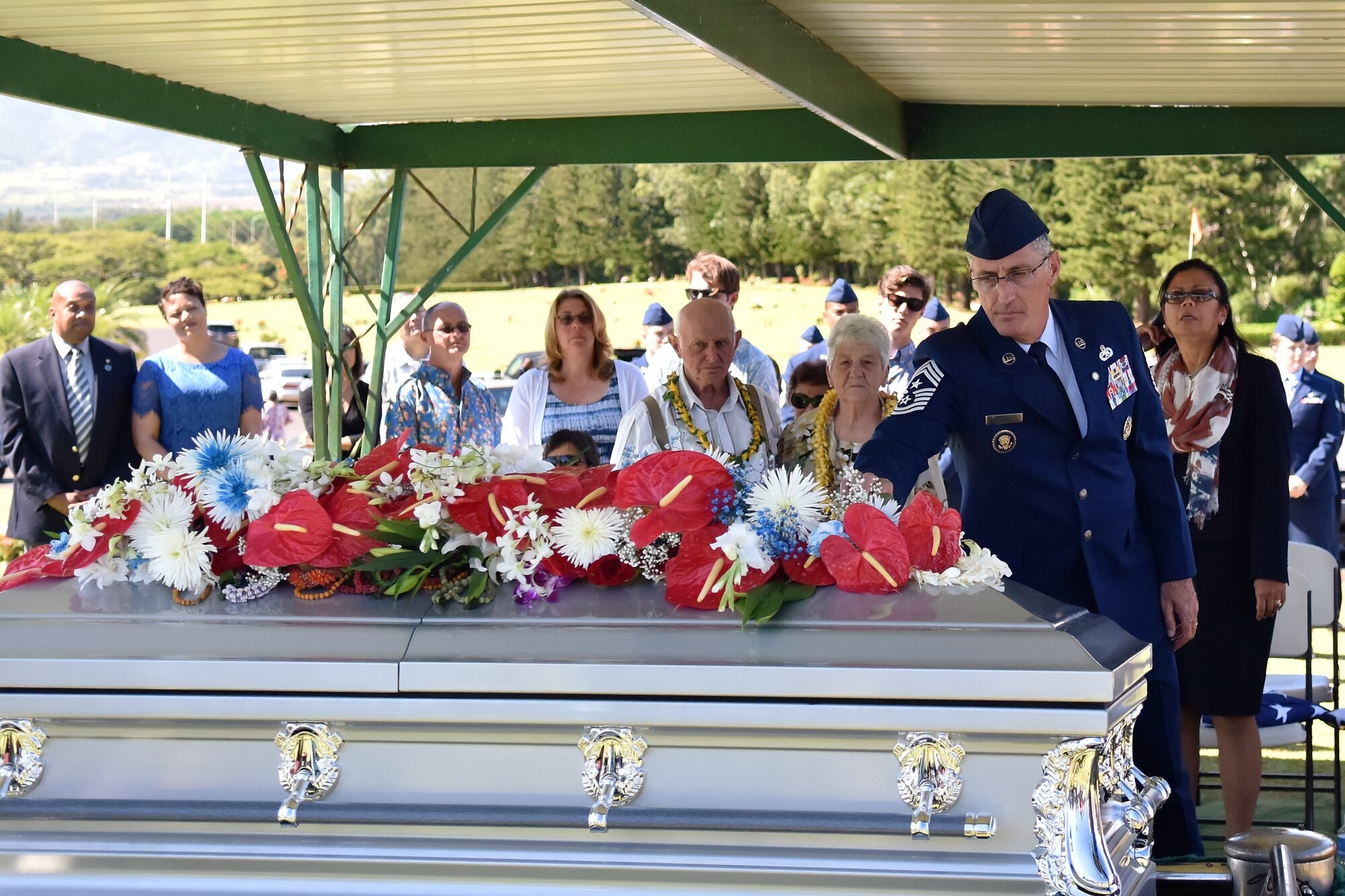 Chief Master Sgt. (Ret.) Jonathan Hake, says a final good bye to his son Senior Airman Jeremy M. Jutba-Hake before he is laid to rest during a memorial service, Tuesday, Jan. 20, 2016, at Mililani Memorial Park, located in Mililani, Hawaii. (U.S. Air Force photo by Staff Sgt. Christopher Stoltz/Released)