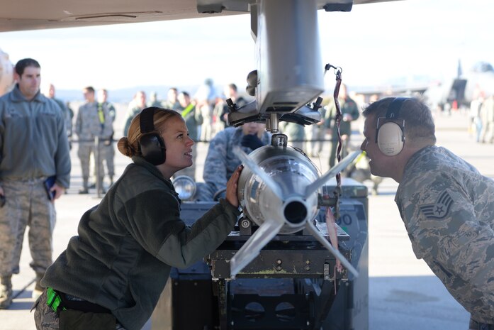 Senior Airman Kelly Sifers and Staff Sgt. Eric McClendon, weapons technician specialist from the 57th Aircraft Maintenance Squadron, Viper AMU, prepare to load munitions on a F-16 during a weapons load competition at Nellis Air Force Base, Nev., Jan 8, 2016. Load crews are evaluated for use of the checklist, safety, and overall speed. (U.S. Air Force photo by Airman 1st Class Nathan C. Byrnes)