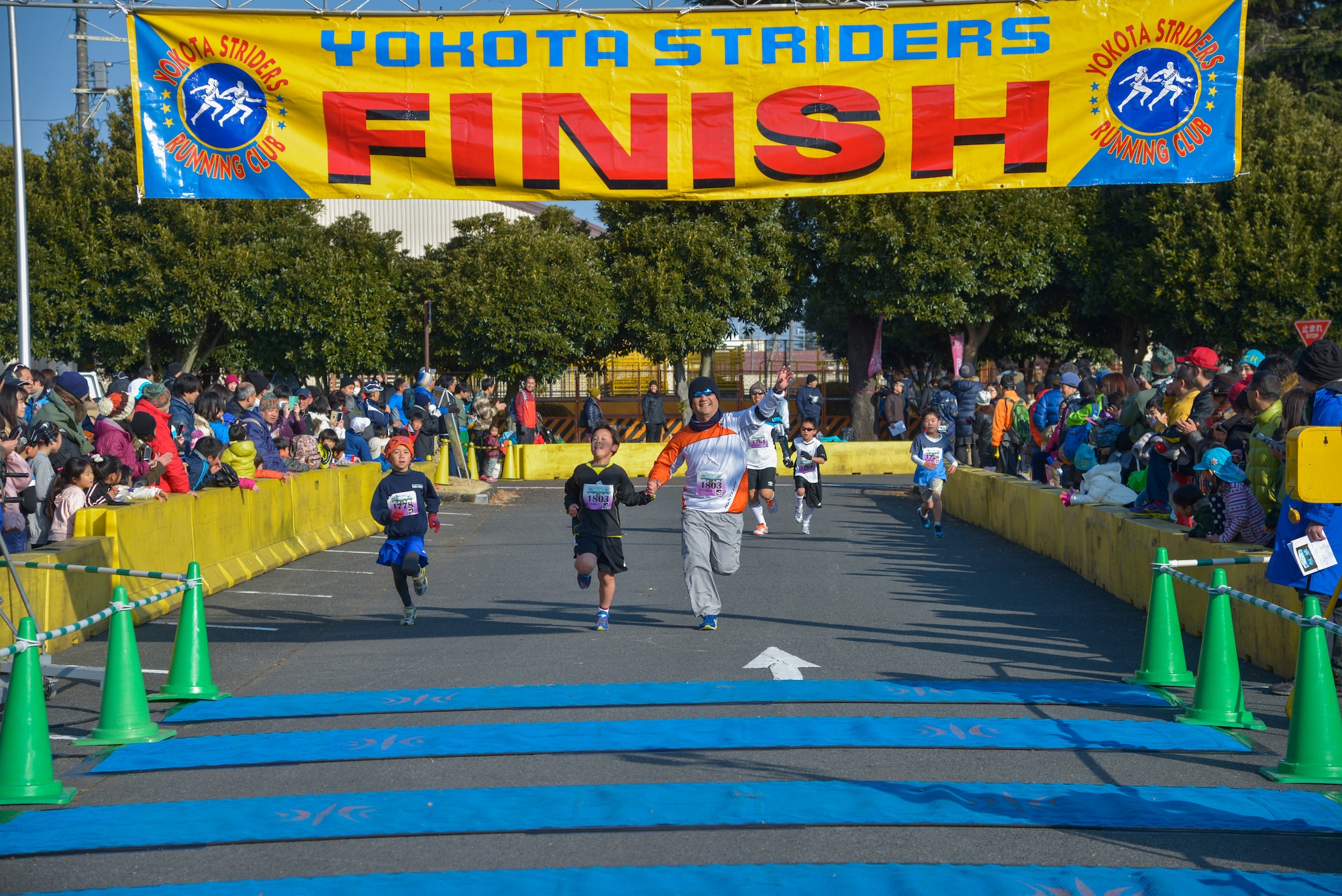People run towards the finish line during the 2k family race during the 35th Annual Frostbite Run at Yokota Air Base, Japan, Jan. 17, 2015. Awards were given to the top three males and females in each race. (U.S. Air Force photo by Senior Airman David Owsianka/Released)