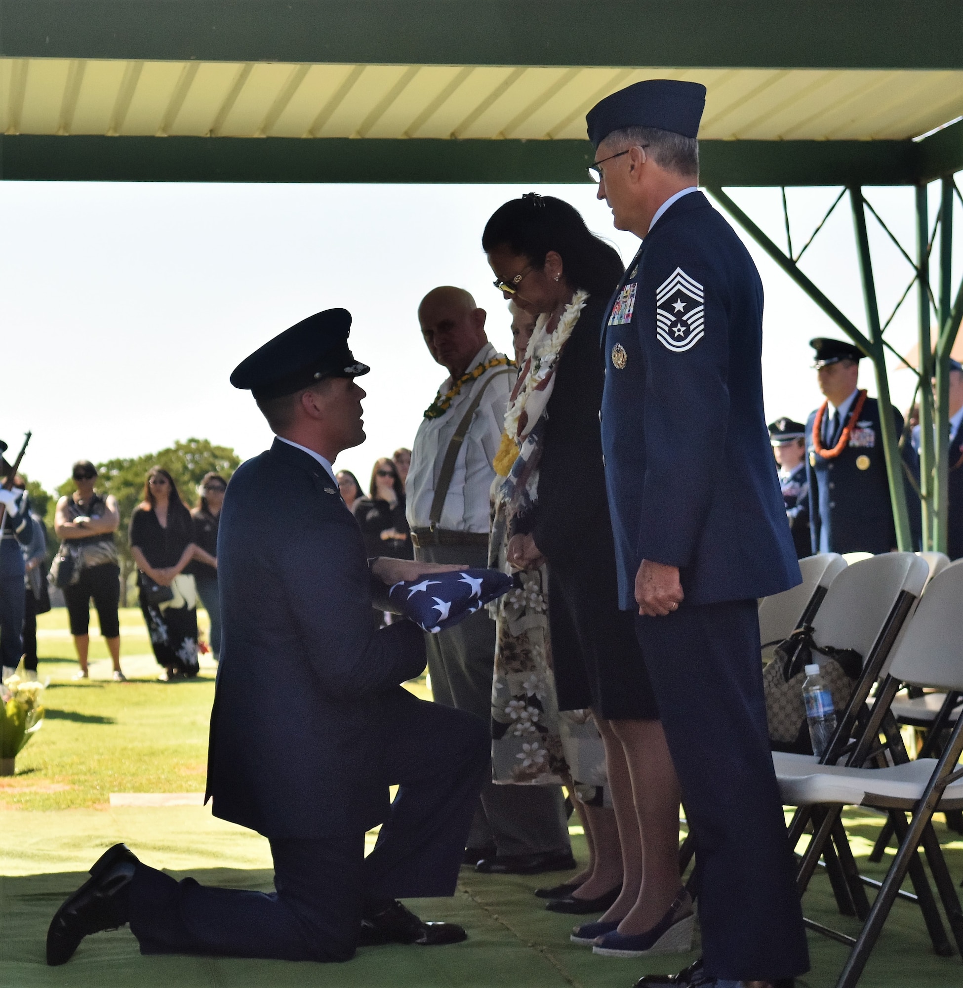Lt. Col. Andrew Campbell, 36th Airlift Squadron commander, presents a folded American flag to Eva Hake during Senior Airman Jeremy M. Jutba-Hake's funeral, Tuesday, Jan. 20, 2016, at Mililani Memorial Park, located in Mililani, Hawaii. (U.S. Air Force photo by Staff Sgt. Christopher Stoltz/Released)