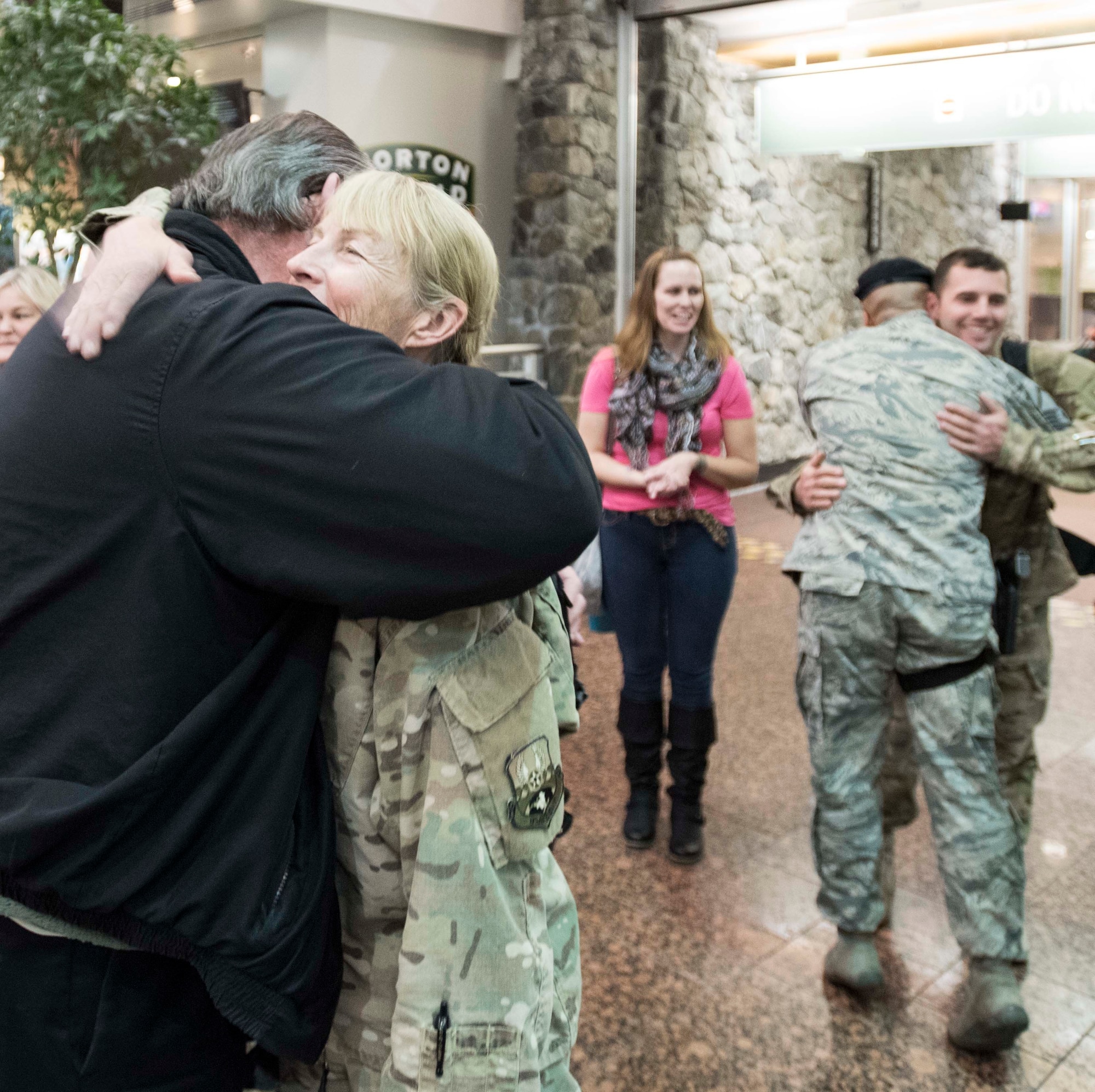 ANCHORAGE, Alaska -- Master Sgt. Bonnie Gardino, utilities supervisor for the Alaska Air National Guard's 176th Civil Engineer Squadron, gets a welcome home hug from former 176th CES member George Waters at the Ted Stevens International Airport here Jan. 13, 2016. Gardino was one of several 176th CES members returning from a six-month deployment in the Middle East. (U.S. Air National Guard photo by Capt. John Callahan/released)