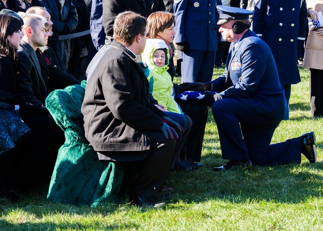 Air Force Office of Special Investigations Commander, Brig. Gen. Keith M. Givens, presents an American Flag at Arlington National Cemetery Jan. 19 to Heather Lamb, the partner of Special Agent Adrianna M. Vorderbruggen who was one of six Airmen killed by a suicide bomber near Bagram Air Base, Afghanistan, Dec. 21, 2015. (U. S. Air Force photo/Michael Hastings) 