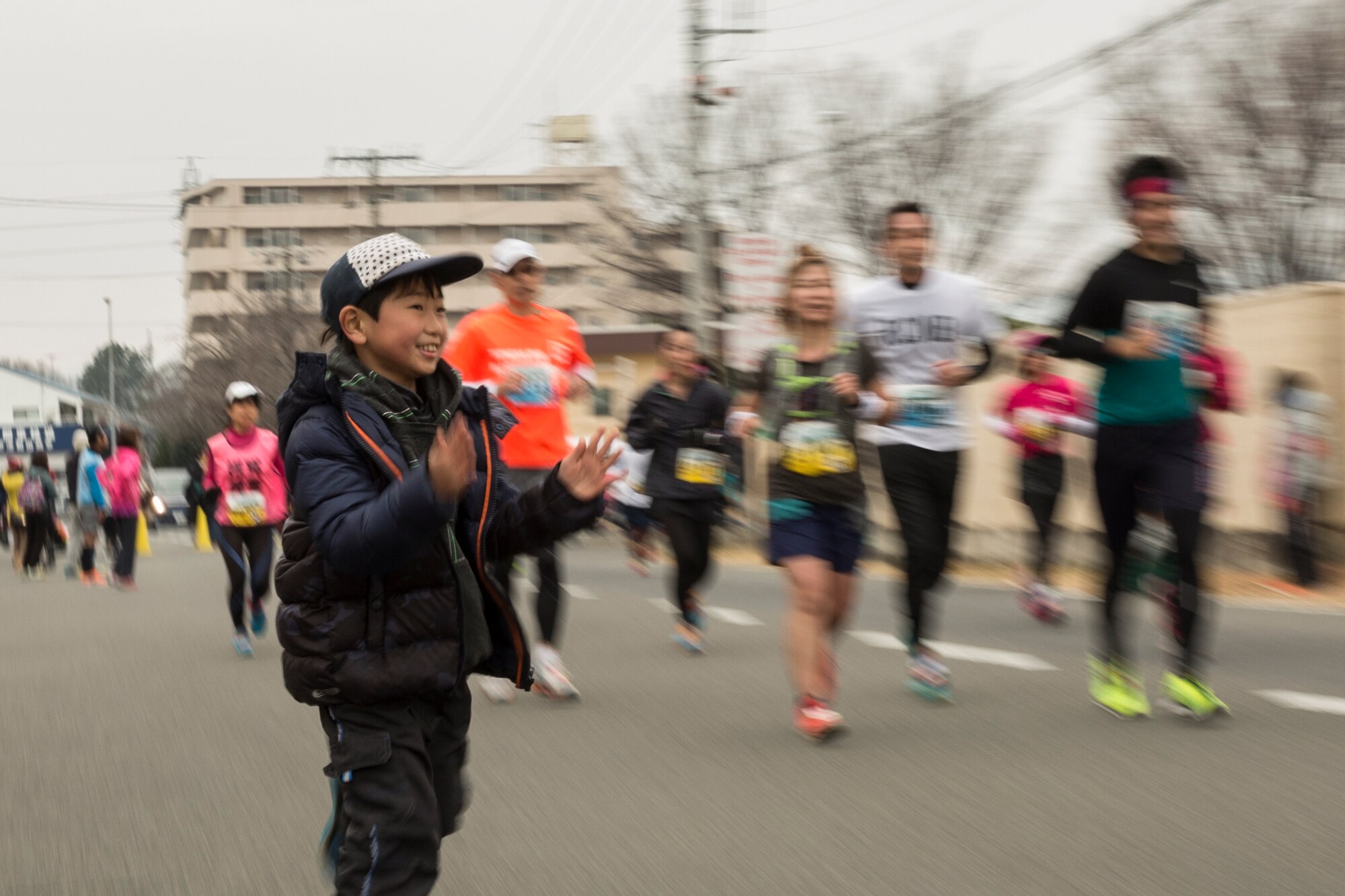 A child encourages participants during the 35th Annual Frostbite Run at Yokota Air Base, Japan, Jan. 17, 2016. Yokota hosted over 9,000 participants for the event.  Akio Tsukamoto won first place by 1:11:05. (U.S. Air Force photo by Osakabe Yasuo/Released)