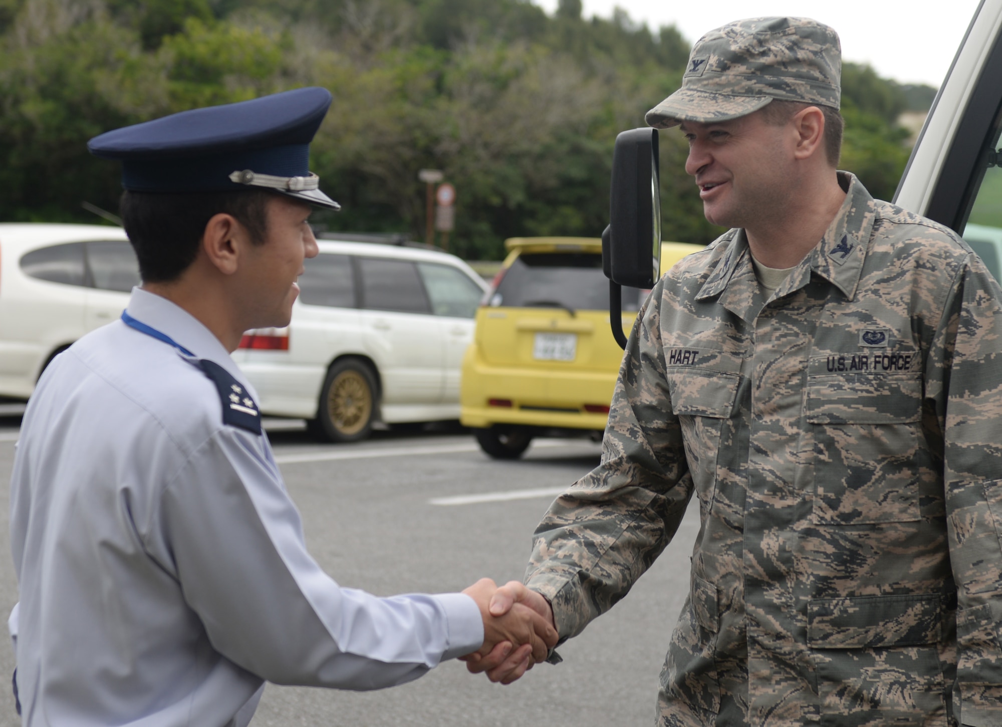 U.S. Air Force Col. Brandon Hart, 18th Wing staff judge advocate, greets Japan Air Self Defense Force Capt. Daisuke Kusabiraki, South West Composite Air Command legal officer, and other members of the JASDF Legal Affairs office Jan. 20, 2016, at Kadena Air Base, Japan. Members of JASDF Legal Affairs visited the 18th Wing legal office to learn about their American counterparts and build friendships. (U.S. Air Force photo by Senior Airman Omari Bernard) 