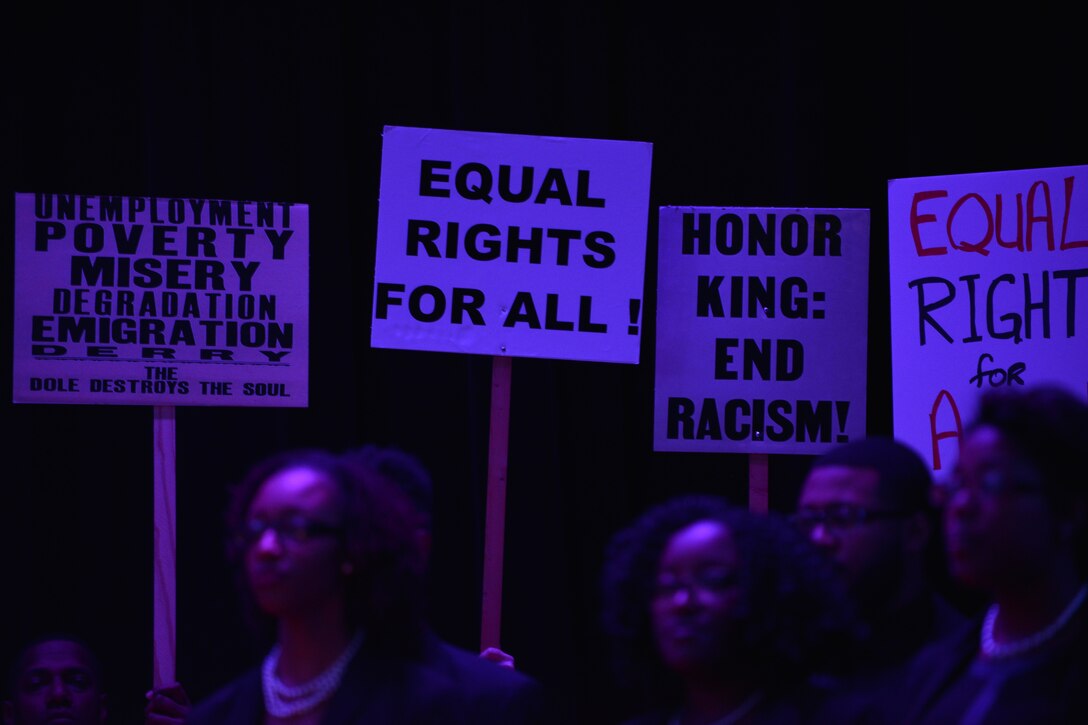 Members of Joint Base Langley-Eustis stage a reenactment by holding civil rights signs during a reading of Dr. Martin Luther King Jr.’s “I Have a Dream,” speech at Fort Eustis, Va., Jan. 13, 2016. The reenactment was a part of Fort Eustis’ Martin Luther King Celebration, which was hosted by the 128th Aviation Brigade. (U.S. Air Force photo by Staff Sgt. Natasha Stannard)