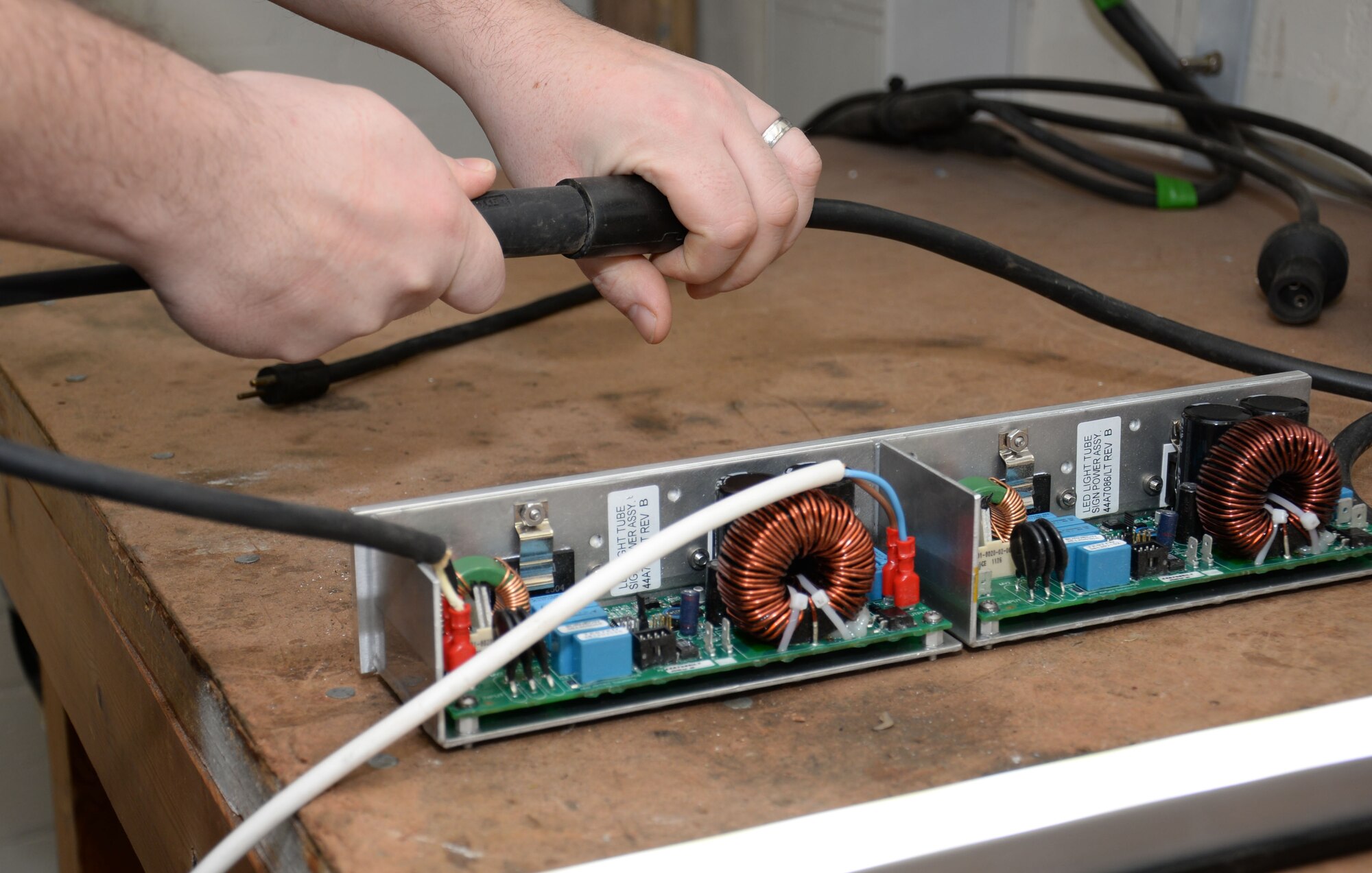 Gary King, 100th Civil Engineer Squadron Airfield Lighting electrician, connects an LED lighting distance-remaining marker power unit for testing Jan. 8, 2016, on RAF Mildenhall, England. The airfield lighting team recently designed, built and implemented a raised perimeter road traffic light system to increase visual awareness for road users. (U.S. Air Force photo by Gina Randall/Released)