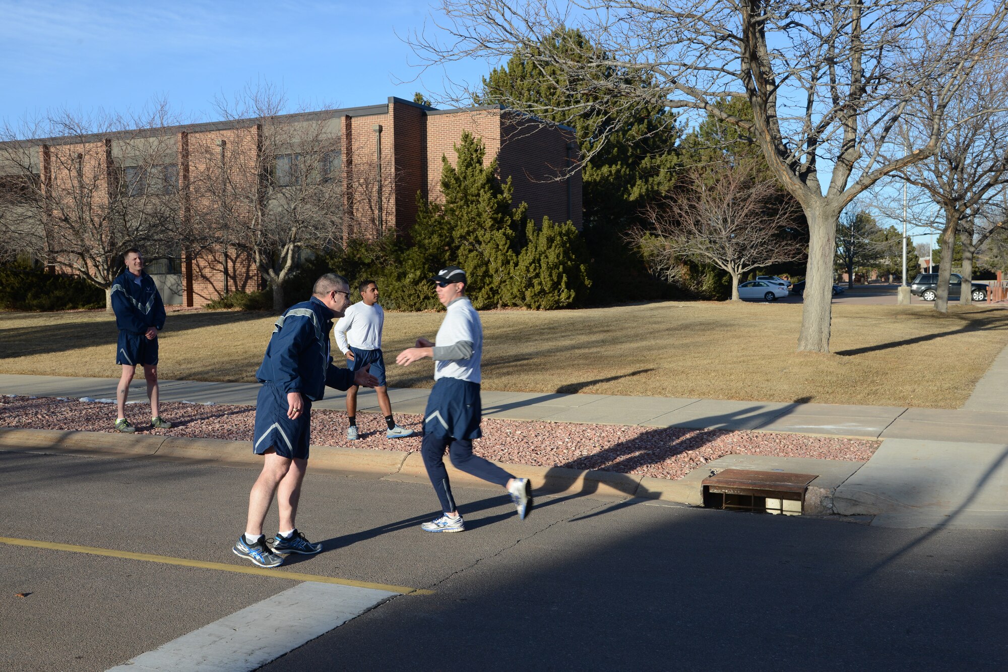 PETERSON AIR FORCE BASE, Colo. – Col. Eric Dorminey, 21st Space Wing vice commander, cheers on Peterson Airmen as they near the finish line during the first Wing Warfit of the year Jan. 19, 2016. The Airmen formed up, performed group and individual stretching and then ran around the golf course. (U.S. Air Force photo by Tech. Sgt. Jared Marquis)