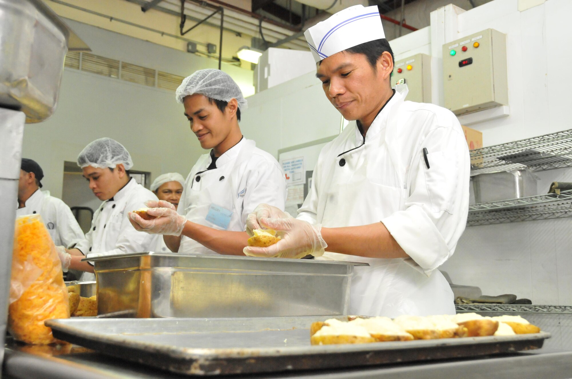 Dining facility staff members prepare a meal for airmen with January birthdays Jan. 12 at Al Udeid Air Base, Qatar.  The 379th Expeditionary Contracting Squadron is responsible for food service contracts at AUAB. The new five year contract has saved the 379th Air Expeditionary Wing an estimated $6 million. (U.S. Air Force photo by Tech. Sgt. Terrica Y. Jones/Released)