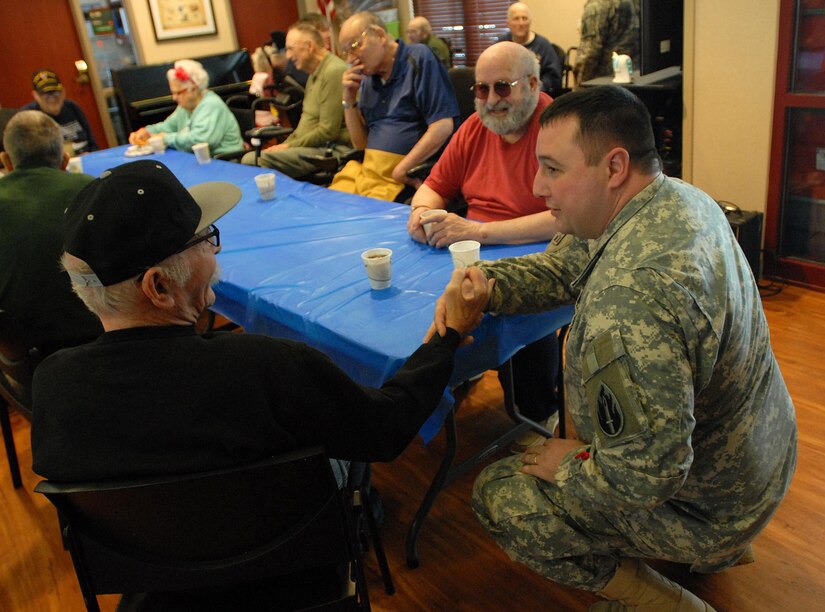 Sgt. Zach Mott, public affairs specialist with the U.S. Army Reserve’s 207th Public Affairs Detachment, swaps stories with a U.S. Army veterans during a visit to the Colorado State Veterans Home at Fitzsimmons, Jan. 9. Mott and the other Soldiers of the 207th PAD ate lunch and visited with the veterans who reside in the Veterans Home.