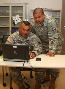 Army Reserve Staff Sgt. Cristin Duenas (right), a platoon sergeant with the 302nd Quartermaster Company – Detachment 1, helps Spc. David Hosono navigate his way through a mandatory online training during the unit’s weekend battle assembly, here, at the U.S. Army Reserve Center, Saipan, Jan. 10. With the increase in resources, more Soldiers are able to complete online trainings at a given time.