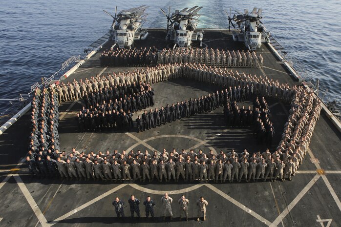 (Jan. 10, 2016) Marines with Combat Logistics Battalion 26, Fox Company and Echo Battery, Battalion Landing Team 2/6, 26th Marine Expeditionary Unit (26th MEU) and Sailors assigned to the amphibious transport dock ship USS Arlington (LPD 24) pose for a photo on the flight deck of Arlington Jan. 10, 2016. The 26th MEU is embarked with the Kearsarge Amphibious Ready Group and is deployed to maintain regional security in the U.S. 5th Fleet area of operations.