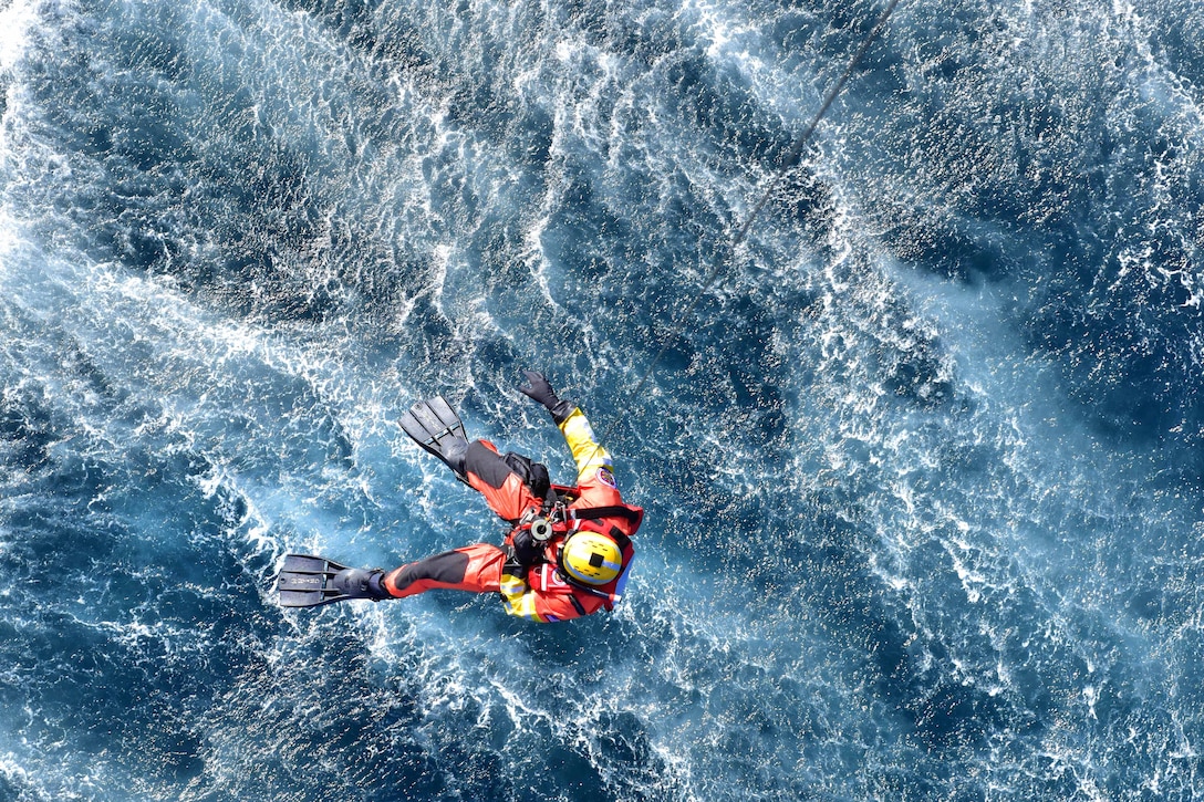 Coast Guard Petty Officer 2nd Class Kris Grimm is lowered into the water from an MH-60 Jayhawk helicopter off the coast of San Diego, Jan. 12, 2016.  U.S. Coast Guard photo by Petty Officer 1st Class Rob Simpson