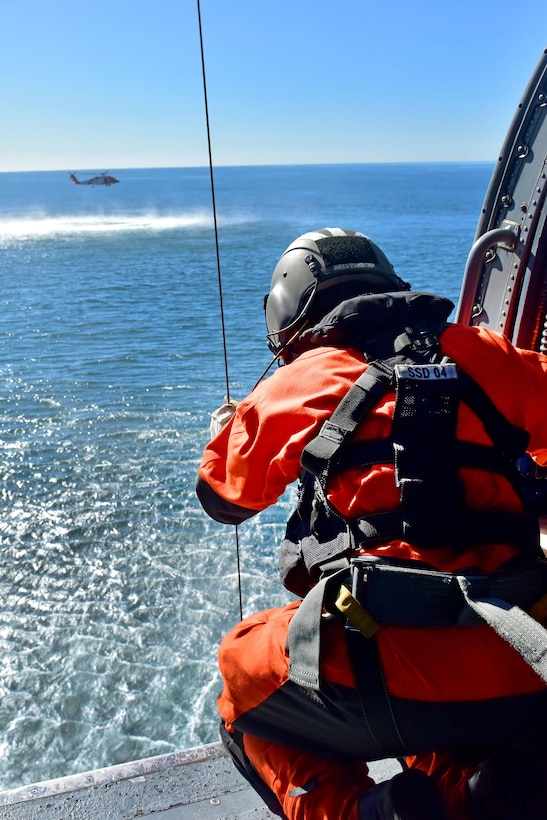 Coast Guard Petty Officer 2nd Class Jay Palacio operates an MH-60 Jayhawk helicopter hoist cable during a training exercise off the coast of San Diego, Jan. 12, 2016. Palacio, an avionics electrical technician, also communicates direction to the pilots. U.S. Coast Guard photo by Petty Officer 1st Class Rob Simpson