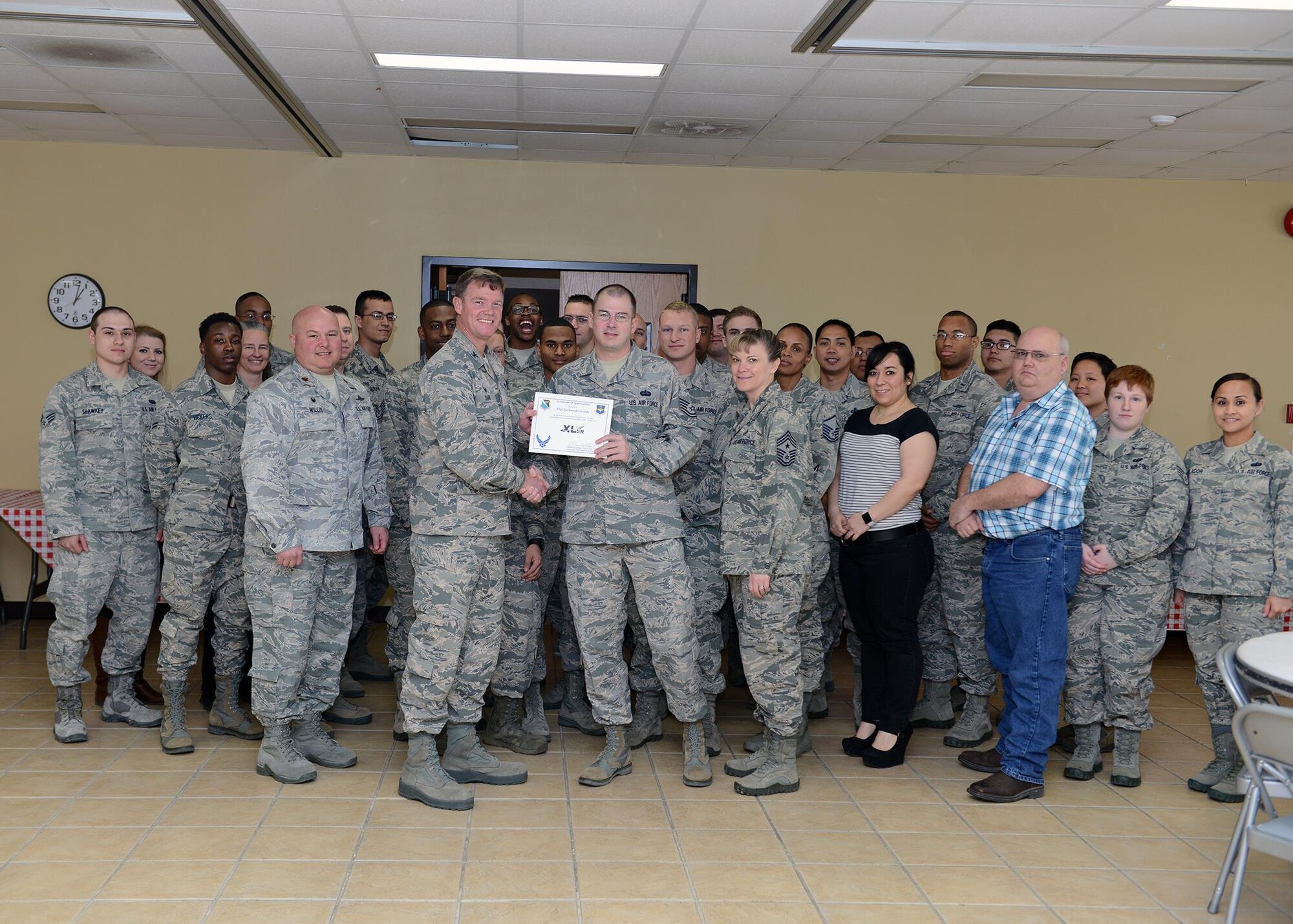 Tech. Sgt. Zachariah Grooms, center, 47th Communications Squadron NCO in charge of Cyber Systems Operations, accepts the “XLer of the Week” award from Col. Thomas Shank, left, 47th Flying Training Wing commander, and Chief Master Sgt. Teresa Clapper, right, 47th FTW command chief, here, Jan. 19, 2016. The XLer is a weekly award chosen by wing leadership and is presented to those who consistently make outstanding contributions to their unit and Laughlin. (U.S. Air Force photo by Senior Airman Jimmie D. Pike)
