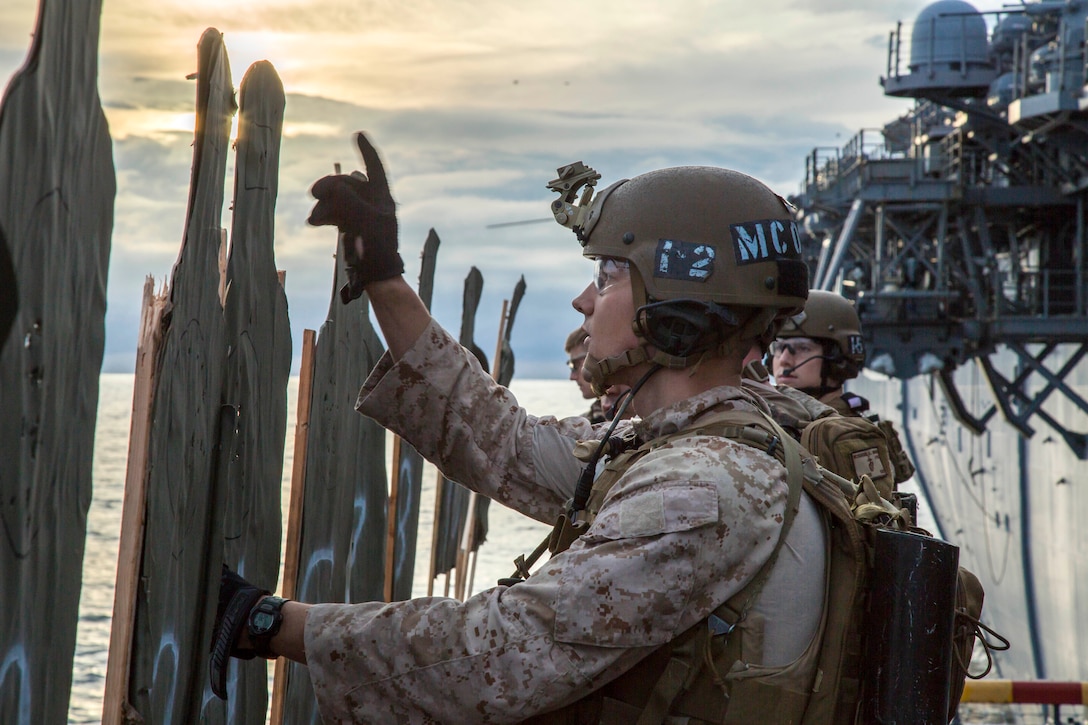 U.S. Marine Sergeant Michael Mcauthey, foreground, counts his impacts on the target after firing during an exercise aboard the USS Boxer at sea, Jan. 18, 2016. Mcauthey is assigned to Maritime Raid Force, 13th Marine Expeditionary Unit. U.S. Marine Corps photo by Sgt. Hector de Jesus