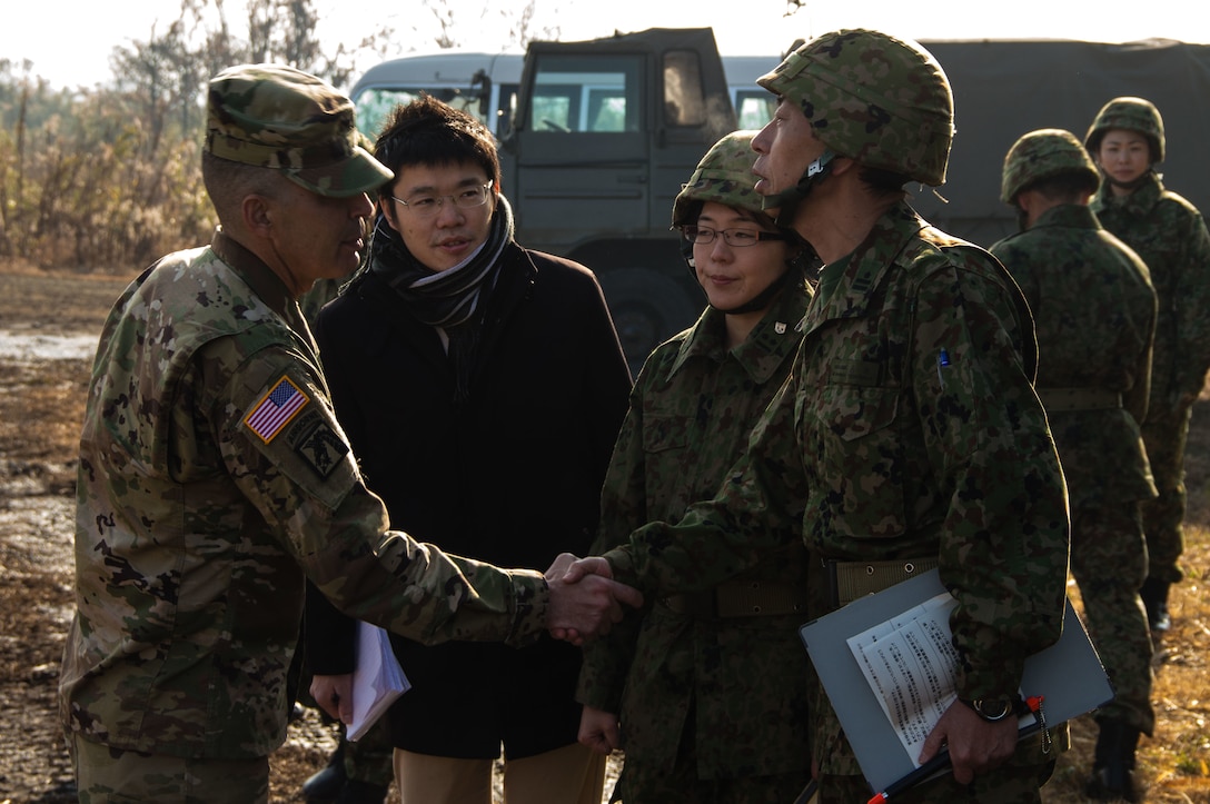 U.S. Army Col. Luis Pomales (left), a San Juan, Puerto Rico, native serving as the director of the Army Reserve Engagement Team-Japan (ARET-J), shakes hands with a Japan Ground Self-Defense Force officer at Kuroishibaru training grounds near Camp Kenjun, Japan, Jan. 16, 2016. The training event was one of several cultural, social and military engagements designed to enhance the bilateral partnership between ARET-J and the JGSDF Western Army's Reserve Component. (U.S. Army photo by Sgt. John L. Carkeet IV, U.S. Army Japan)