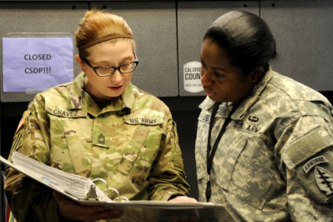 Army Master Sgt. Amber Chavez, left, the logistics noncommissioned officer in charge for 10th Special Forces Group (Airborne), mentors a junior soldier as she trains her in Army logistics at Fort Carson, Colo, Jan. 12, 2016. Chavez said she believes mentoring and training soldiers and possessing an inner drive to professionally improve every day are key components to success in the Army. U.S. Army photo by Staff Sgt. Jorden M. Weir