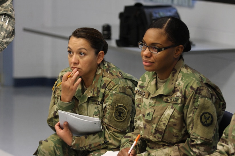 U.S. Army Reserve Soldiers Sgt. 1st Class Monica Waldron, Headquarters, United States Army Recruiting Command, Fort Knox, Ky., left and Sgt. Kancice Chavis, 535th Military Police Battalion, 290th Military Police Brigade, 200th Military Police Command, listen as fellow classmates of the Equal Opportunity Leaders Course determine who has to leave a "sinking lifeboat" during the course's Life Raft Exercise at the 11th Theater Aviation Command's Headquarters  Nov. 18, 2015. (U.S. Army photo by Clinton Wood/Released).