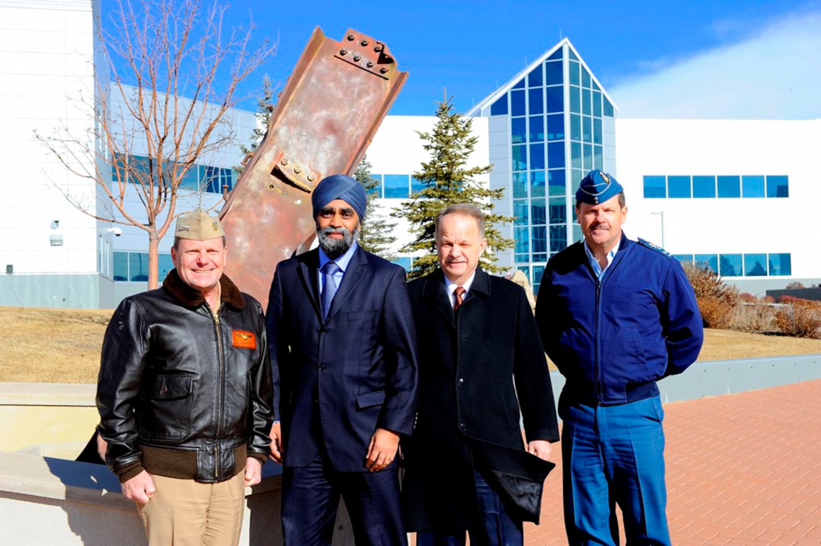 Admiral Bill Gortney, Commander of the North American Aerospace Defence Command (NORAD) and U.S. Northern Command (USNORTHCOM), together with, Defence Minister Harjit S. Sajjan, John Forster, Deputy Minister of National Defence, and Canadian Lieutenant-General Pierre St-Amand, Deputy Commander of NORAD, pose for a photo in front of the 9/11 memorial at NORAD headquarters in Colorado on January 20, 2016. Photo by Jhomil Bansil/released.