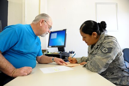 LaMarr Queen, Joint Base San Antonio-Randolph Tax Center coordinator, assists Staff Sgt. Nelly Hensley, in preparing her 2015 income tax returns, Jan. 15, 2016. The tax office will help military members, retirees and family members complete their 2015 income tax returns before the April 15 deadline.  (U.S. Air Force photo by Joel Martinez/Released)