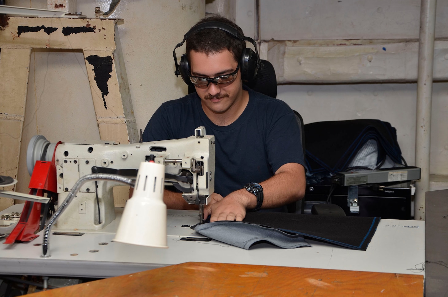 160119-N-VH871-006 DIEGO GARCIA, British Indian Ocean Territory (Jan. 19, 2016) Hull Repair Technician Fireman Zachary James assigned to the submarine tender USS Emory S. Land (AS 39) sews together pieces of Naugahyde to make a seat cover for the guided missile submarine USS Florida (SSGN 728) as part of a continuous maintenance availability. Emory S. Land is a forward deployed expeditionary submarine tender on an extended deployment conducting coordinated tended moorings and afloat maintenance in the U.S. 5th and 7th Fleet areas of operations. (U.S. Navy photo by Mass Communication Specialist 3rd Class Austin L. Ingram/Released)