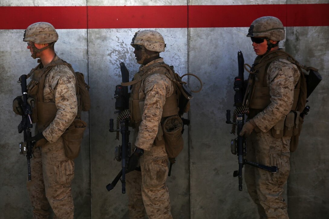 Machine gunners assigned to Company C, 1st Battalion, 1st Marine Regiment, 1st Marine Division, wait for adjacent units to clear a building during military operations in urban terrain, as part of combined arms live-fire training, Marine Rotational Force – Darwin exercise, aboard Marine Corps Air Ground Combat Training Center Twentynine Palms, Calif., Jan. 17, 2016. The Marines completed the training as part of their preparations for an upcoming deployment to Australia.