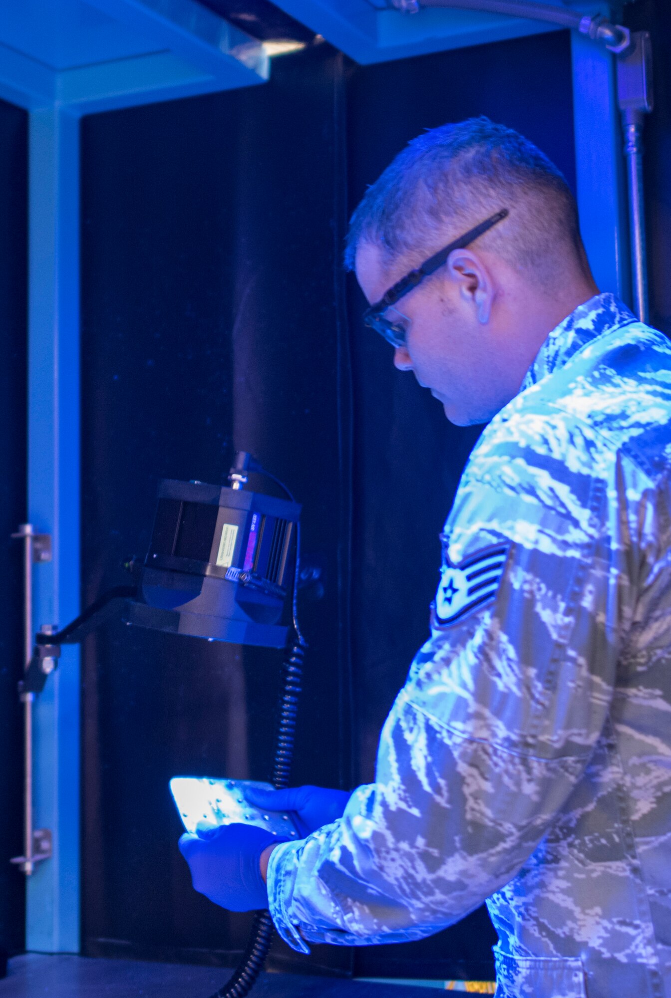 Staff Sgt. Matthew Barnes, 366th Equipment Maintenance Squadron non-destructive inspections craftsman, performs a fluorescent penetrate inspection on a bracket from a F-15E Strike Eagle, Jan. 15, 2016 at Mountain Home Air Force Base, Idaho. This inspection is used on aluminum parts or those that are non-magnetic.(U.S. Air Force photo by Senior Airman Jeremy L. Mosier/Released)