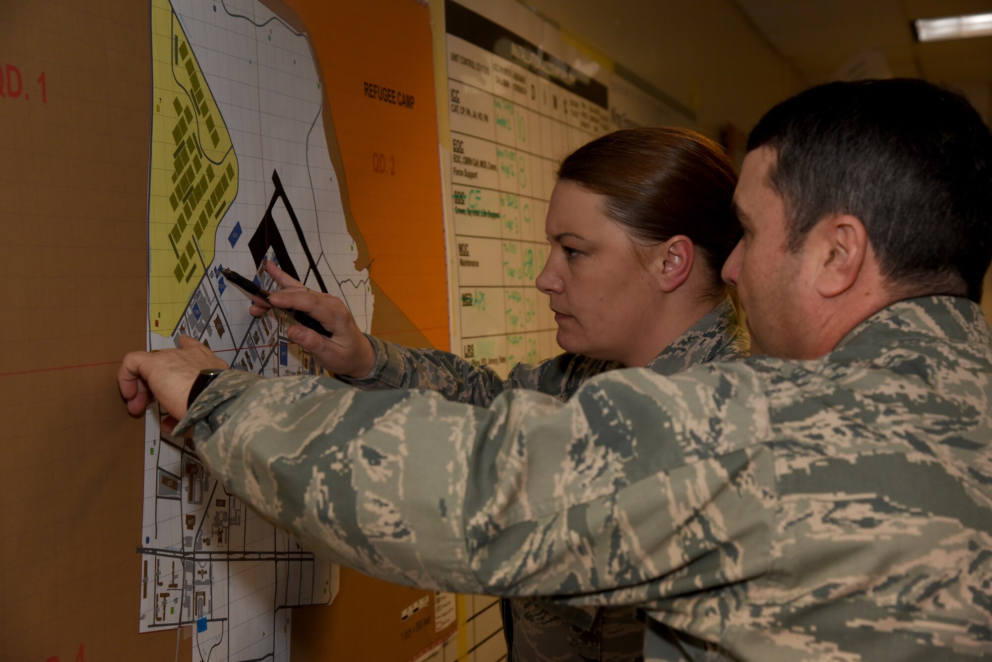 Master Sgt. Jennifer Simmons, National Disaster Program Manager for the Army Corps of Engineers, looks over a map with Maj. Joseph Terry, commander of the 403rd Logistics Readiness Squadron, in the Emergency Operations Center during Exercise Agile Sabre Jan. 14, 2016 at Keesler Air Force Base, Mississippi. (U.S. Air Force photo/Staff Sgt. Nicholas Monteleone)