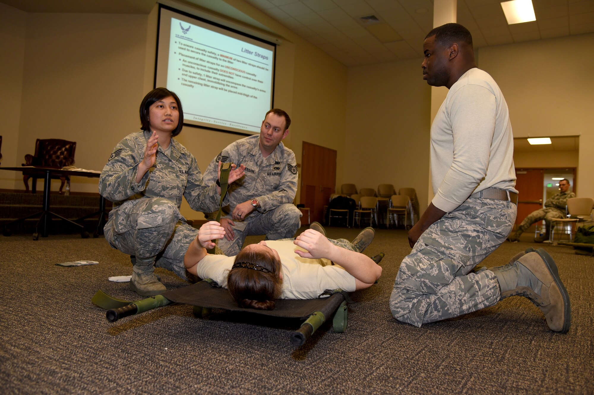 Staff Sgt. Gabrielle Atajar, a medic with the 81st Medical Group, instructs members of the 403rd Wing on proper techniques for strapping a patient to a litter at the Roberts Consolidated Maintenance Facility at Keesler Air Force Base, Mississippi, Jan. 11, 2016. The training was part of the Exercise Agile Sabre Jan. 11-15, 2016. (U.S. Air Force photo/Staff Sgt. Nicholas Monteleone)