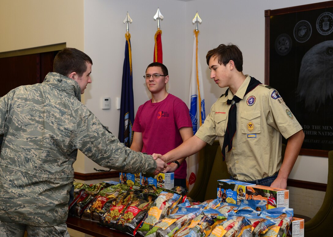 Gabriel Curcione, vice president of the New York Air National Guard Teen Leadership Council looks on as Harrison Abramaitys, member of Boy Scouts of America Troop 816, shakes hands with a member of the 914th Airlift Wing on Saturday, January 9, 2016. Curcione and Abramaitys were handing out popcorn from a donation by the Boy Scouts of America of the Greater Niagara Frontier Council. (U.S. Air Force photo by Staff Sgt. Richard Mekkri)