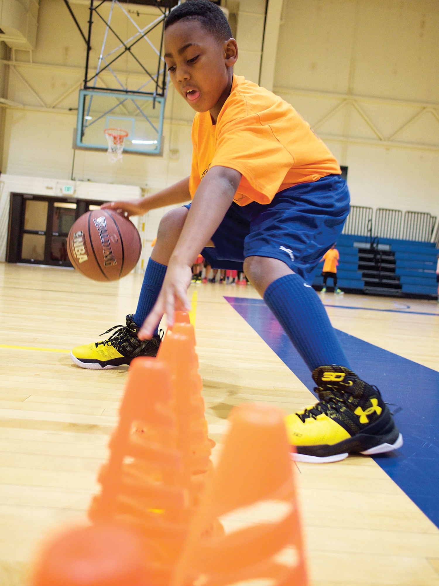 Braeden Speakman, a Youth Development Program athlete, carries out a drill Jan. 7 at the Elmendorf Fitness Center. Speakman and other TYDP participants focus on basketball fundamentals courtside while working to get good marks in school. (U.S. Air Force photo by David Bedard)