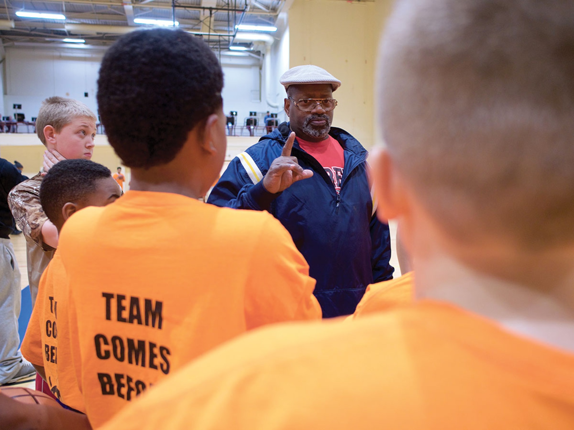 Arnold Dade, The Youth Development Program president, coaches TYDP athletes Jan. 7 at the Elmendorf Fitness Center. Participants in TYDP focus on basketball fundamentals courtside while working to get good marks in school. (U.S. Air Force photo by David Bedard)