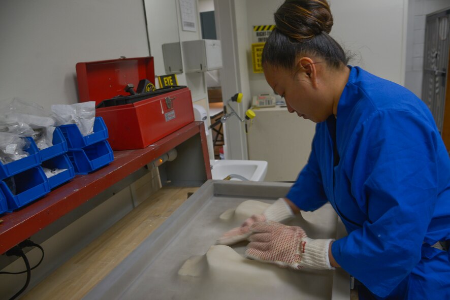 Tech. Sgt. Joy Victoria, 374th Surgical Operations Squadron orthotics NCO in charge, ensures a vacuum press is tightly pressed on the polypropylene plastic over a foot mold at Yokota Air Base, Japan, Jan. 20, 2016. Once the plastic is molded to a person’s foot, the patient will receive the inserts. (U.S. Air Force photo by Senior Airman David Owsianka/Released) 