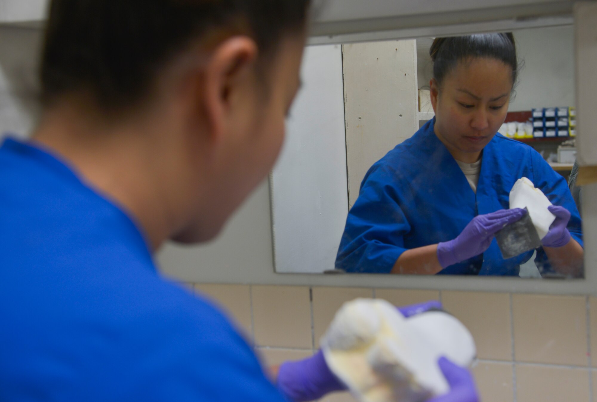 Tech. Sgt. Joy Victoria, 374th Surgical Operations Squadron orthotics NCO in charge, fixes impurities on a foot mold by adding plaster and smoothing any rough edges at Yokota Air Base, Japan, Jan. 20, 2016. There are only five bases in the Air Force with an Orthotics Lab, and Yokota is the sole supporter of orthotics for the Pacific Air Forces. (U.S. Air Force photo by Senior Airman David Owsianka/Released)