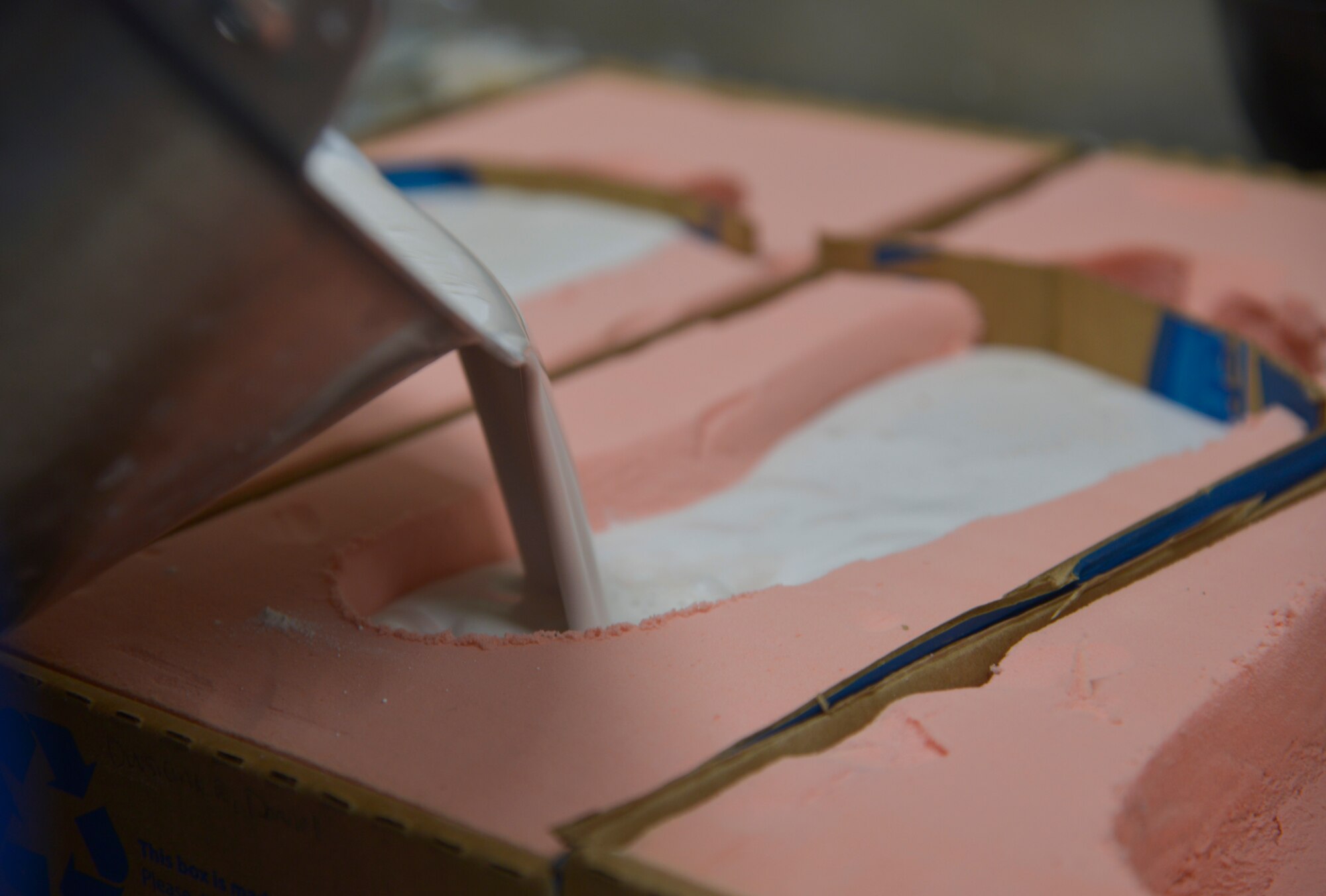 Tech. Sgt. Joy Victoria, 374th Surgical Operations Squadron orthotics NCO in charge, pours plaster into impression foam to make a foot mold at Yokota Air Base, Japan, Jan. 20, 2016. It takes approximately 15 minutes for the plaster to dry. (U.S. Air Force photo by Senior Airman David Owsianka/Released)