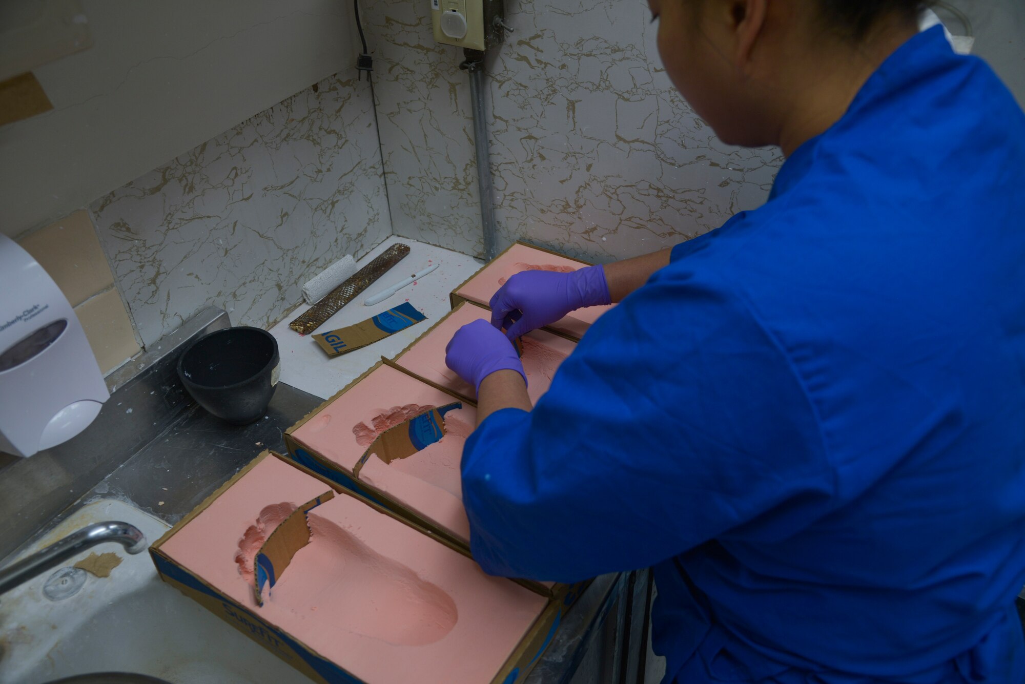 Tech. Sgt. Joy Victoria, 374th Surgical Operations Squadron orthotics NCO in charge, preps impression foam prior to it being filled with plaster at Yokota Air Base, Japan, Jan. 20, 2016. The orthotics lab helps maintain a physically fit and healthy military community. (U.S. Air Force photo by Senior Airman David Owsianka/Released)