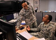Staff Sgt. Sarah Timberlake, 319th Logistics Readiness Squadron traffic management journeyman, mentors Airman 1st Class Brandon Massiah, 319th LRS traffic management apprentice on how to use their traffic management program on Grand Forks Air Force Base, North Dakota. Massiah was born in Trinidad and Tobago, San Fernando and is on his way to become U.S. citizen through the help of the U.S. military. (U.S. Air Force photo by Senior Airman Xavier Navarro/Released)