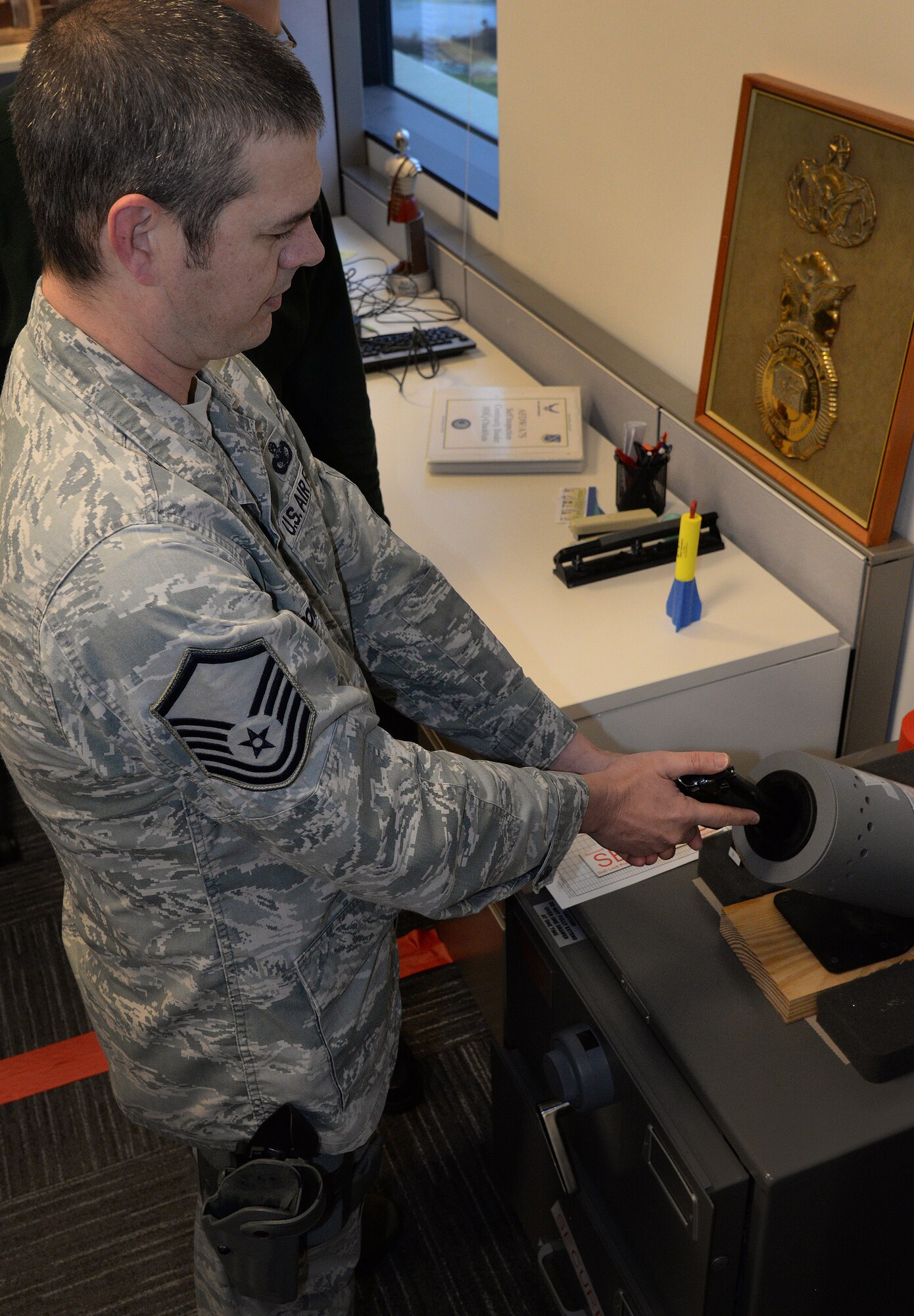 Master Sgt. Chris Romano, Air Force District of Washington Security Forces Plans and Programs Branch superintendent, clears his M9 service pistol at the William A. Jones III building on Joint Base Andrews, Md., Dec. 30, 2015. Staff arming allows AFDW personnel with an SF background to be armed in the building while working in a staff position to prevent active shooter threats. (U.S. Air Force photo/1st Lt. Esther Willett)
