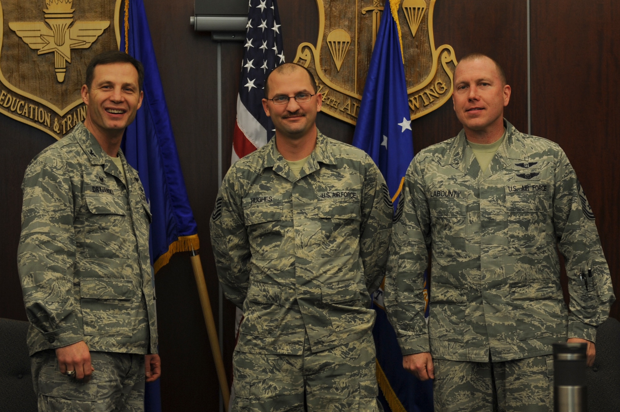 Col. James Dryjanski, 314th Airlift Wing commander, along with Chief Master Sgt. Brian Labounty, 314th Airlift Wing command chief, congratulate Tech Sgt. Bryan Hughes, a 314th Operations Group client system technician, on his selection as Combat Airlifter of the Week Jan. 20, 2016, at Little Rock Air Force Base, Ark. (U.S. Air Force photo by Senior Airman Harry Brexel)