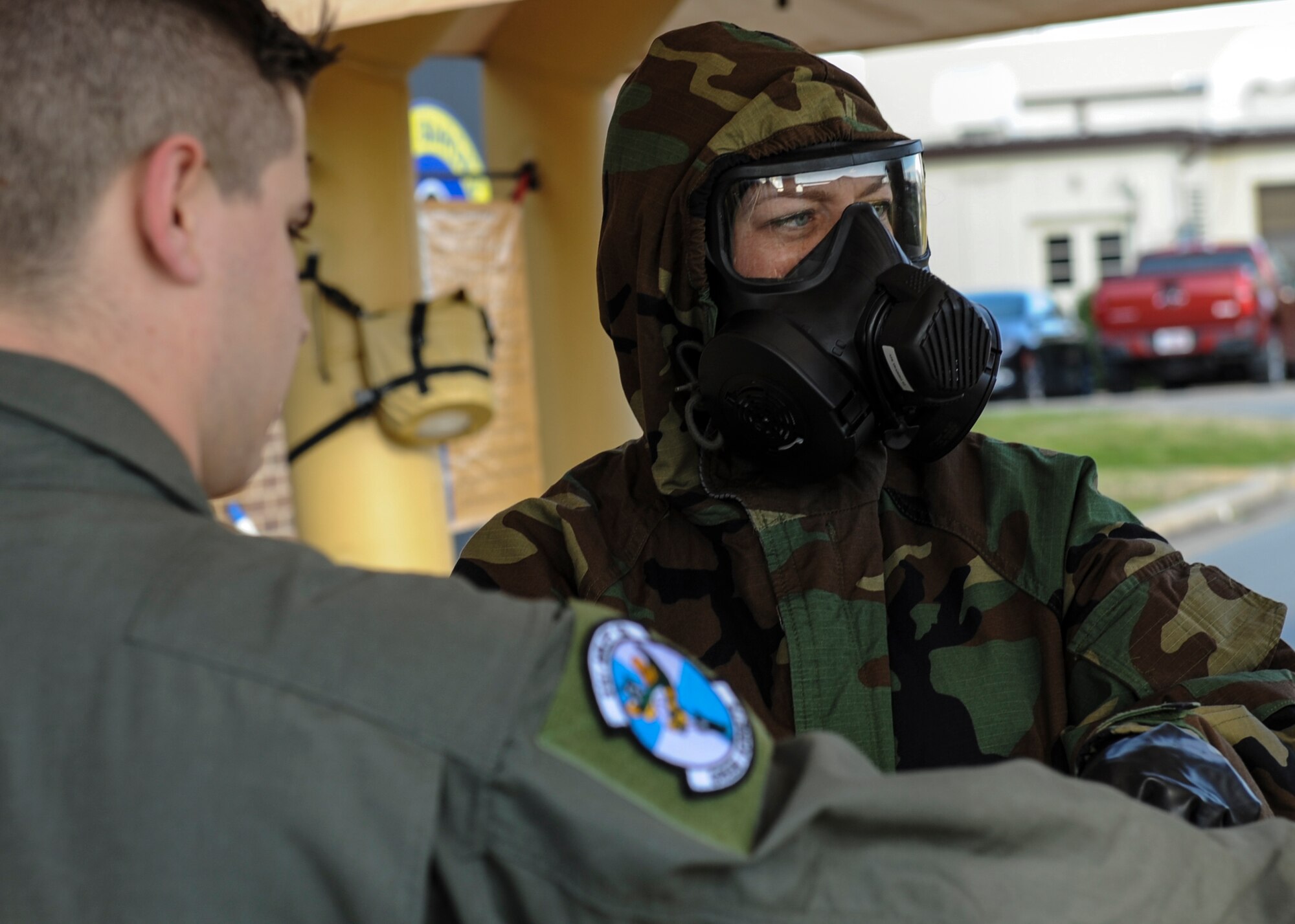 U.S. Air Force Staff Sgt. Angela Pratt, 19th Operations Support Squadron aircrew flight equipment technician, checks procedures while decontaminating a 61st Airlift Squadron C-130J loadmaster during an exercise Jan. 14, 2016, at Little Rock Air Force Base, Ark. To avoid cross-contamination, aircrew flight equipment Airmen working the decon line must wear Mission Oriented Protective Posture gear, which consists of an over garment, over boots, gloves, and a protective/respiratory. (U.S. Air Force photo/ Senior Airman Harry Brexel)