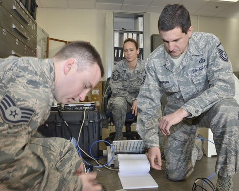 Master Sgt. Steve Griffith, 117th Air Refueling Wing Command Post Superintendent along with controller Master Sgt. Leeann Bankhead observe as Staff Sgt. Charles O'Rourke checks equipment during a recent exercise January 21 2015. (U.S. Air National Guard photo by: Senior Master Sgt. Ken Johnson/Released)