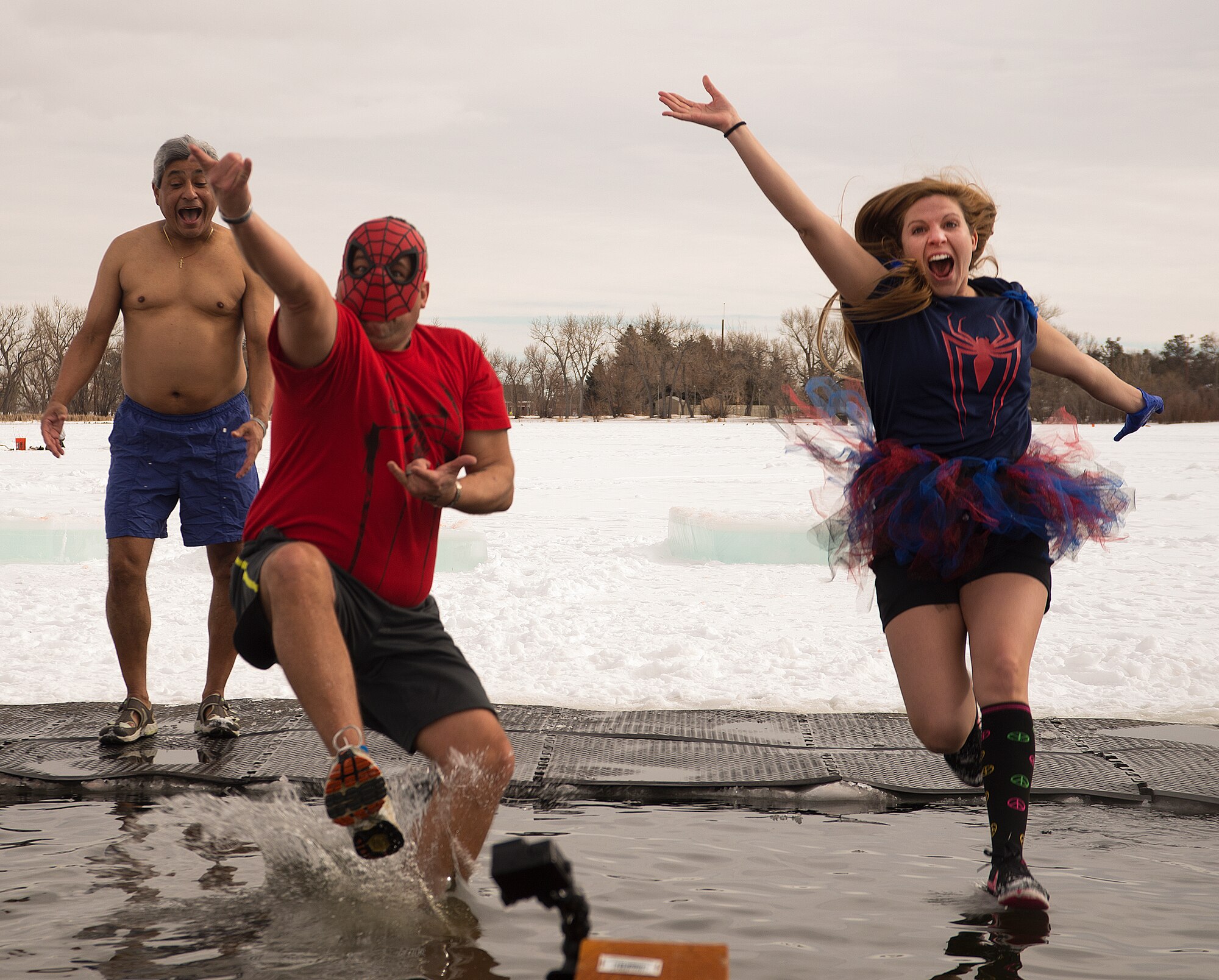 Gene Duran, 90th Civil Engineer Squadron, and Racheal Comisky, 90th Force Support Squadron Child Development Center, leap into the freezing waters of Cheyenne’s Sloan Lake January 16, 2016. Gil Ferrel, 90th CES, hesitated before braving the Wyoming cold for a quick dip during the fourth-annual Matthew S. Schwartz Memorial Polar Plunge. (U.S. Air Force photo by R.J. Oriez)